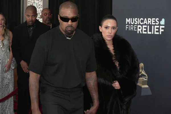 foto colorida de Kanye West e Bianca Censori, ambos de roupas pretas, andando - metrópoles