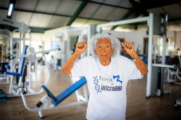 Imagem colorida de idosa mostrando os músculos para a foto - Metrópoles