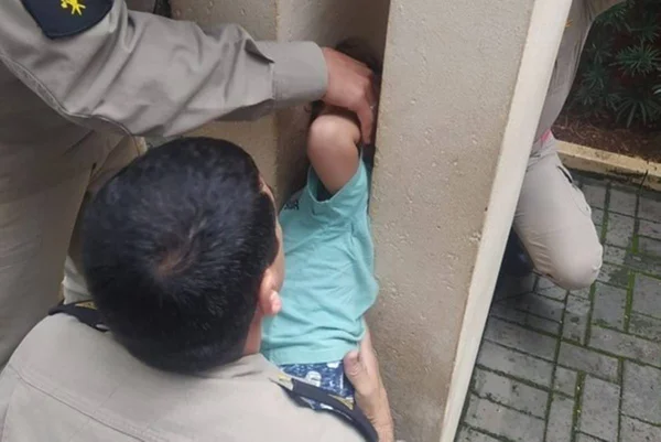 Criança com cabeça presa