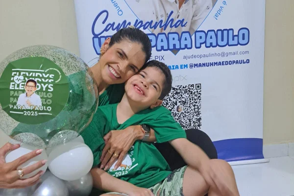 A mãe, Emanuelle Varela, abraçada com o filho Paulo Varela. Os dois estão vestido com camisa verdes da campanha para que Paulo receba o Elevydis