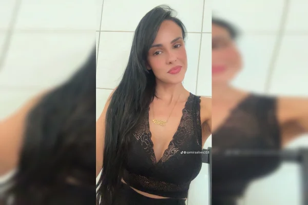 Imagem colorida de uma mulher branca, de óculos, cabelos lisos e roupa preta