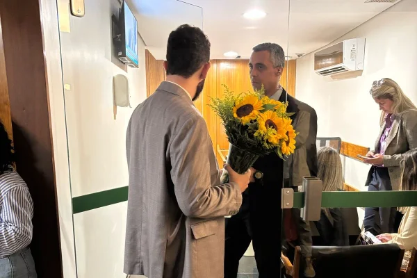 Filho da deputada Carla Zambelli, de costas, com um buquê de flores na mão - Metrópoles