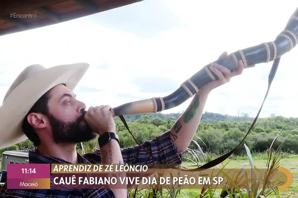 O repórter Cauê Fabiano toca berrante no programa Encontro, da Globo