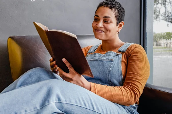 Imagem colorida de mulher lendo um livro - Metrópoles