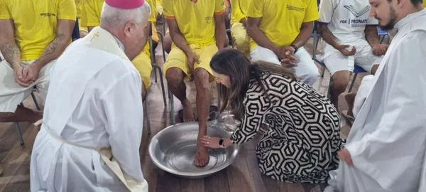 Imagem colorida de juíza lavando pé de detento - Metrópoles