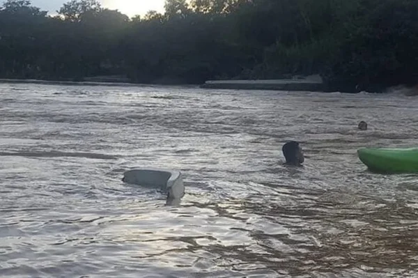 Imagem mostra rio emagitado em que uma pessoa nada - Metrópoles