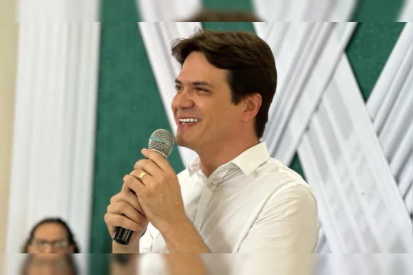Foto colorida do prefeito de Baturité-CE, Herberlh Mota, de camisa branca e usando microfone