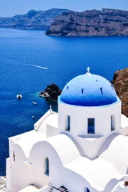Igreja ortodoxa grega com a tradicional cúpula azul, na ilha de Santorini, na Grécia, com vista para o Mar Egeu