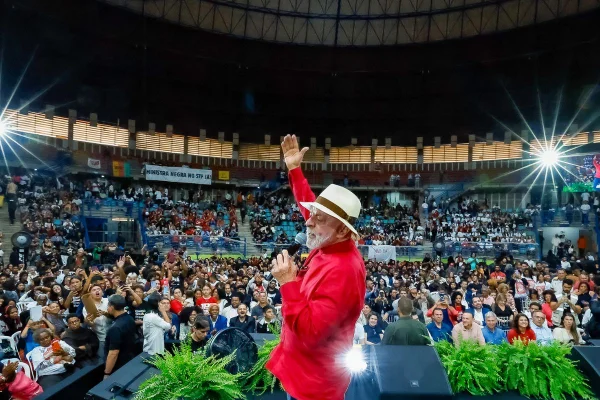 imagem colorida mostra lula em ginásio. ele usa uma blusa vermelha e chapéu