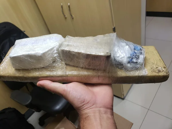 Foto de haxixe e cocaína sob uma tábua
