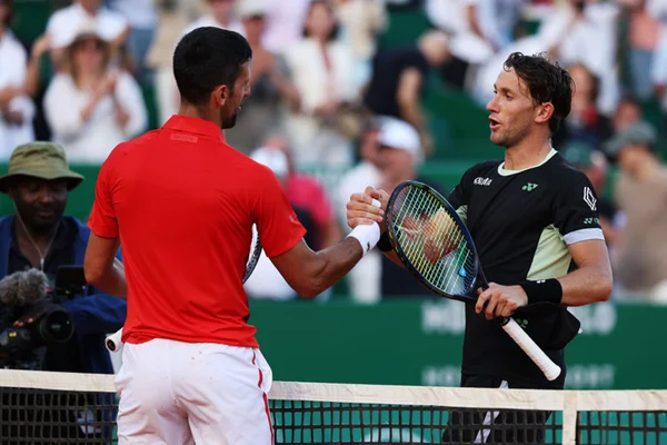 Imagem colorida de Djokovic e Ruud se cumprimentando - Metrópoles