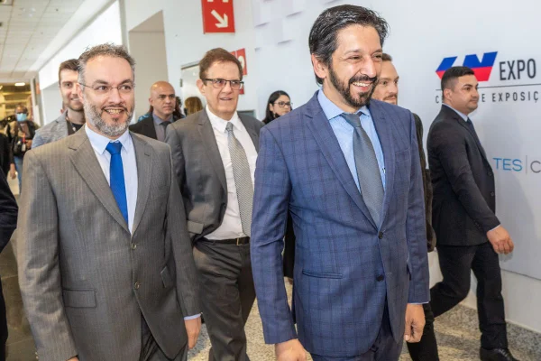 Imagem colorida mostra Ricardo Nunes e Fernando Padula andando na Bienal do Livro - Metrópoles