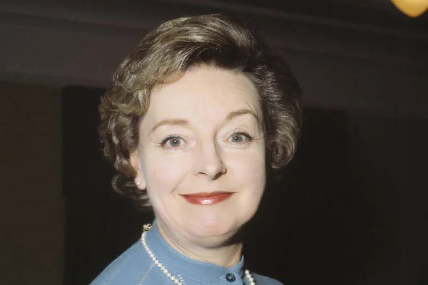 Imagem colorida da atriz Barbara Leigh-hunt, sorrindo para a foto e usando roupa azul - Metrópoles