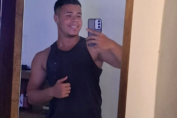 imagem colorida mostra jovem sorrindo em foto tirada no espelho.