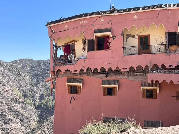 Foto colorida de uma casa rosa destruída após terremoto no Marrocos