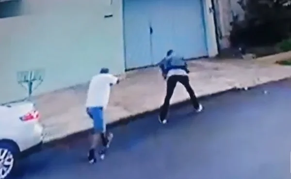 print de um vídeo. na gravação, um homem aparece atirando em um jovem