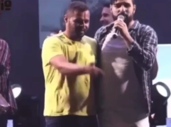 homem em palco com cantor