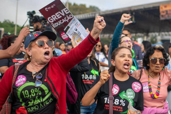 Fotografia colorida de profissionais da educação em assembleia sobre greve