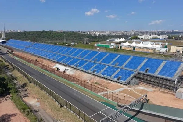 Imagem do setor G de Interlagos, mostra arquibancadas azuis e um pedaço da pista de corrida de Interlagos