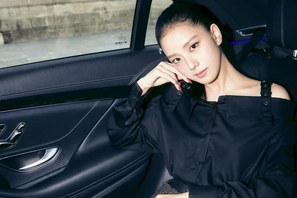foto colorida de mulher branca oriental vestida de blusa preta com cabelo amarrado e sentada em carro - metrópoles