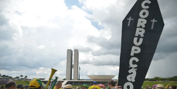 Manifestantes na Esplanada levantam cartaz em formato de caixão escrito corrupção