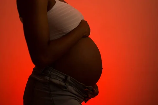 Mulher grávida com mão na barriga - Metrópoles