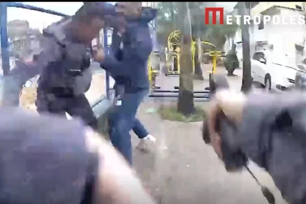 Foto colorida mostra homem reagindo à prisão e sendo baleado por policial.