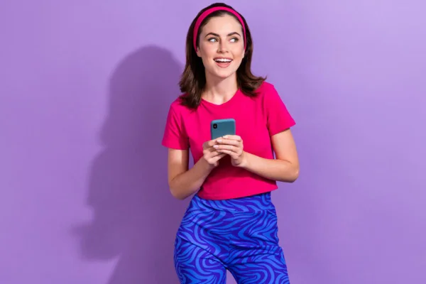 Mulher segurando um celular e sorrindo