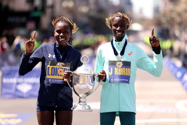 Vencedores da Maratona de Boston, Sharon Lokedi e John Korir, posando com troféu da prova de corrida.