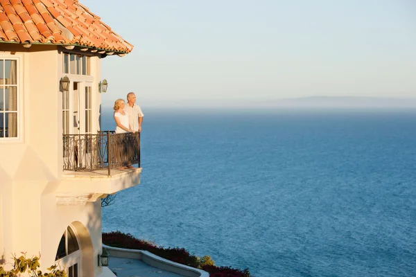 Casal heterossexual, brancos, em uma varanda com vista para o mar - Metrópoles.