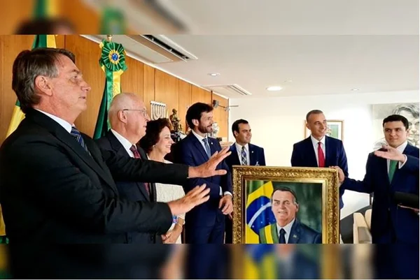 Bolsonaro recebeu os evangélicos no gabinete junto com a deputada Carla Zambelli. Na foto ele gesticula diante de um desenho seu com a faixa presidencial - Metrópoles