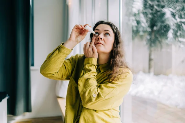 Mulher usando colírio em casa durante o inverno. Metrópoles olho seco seca