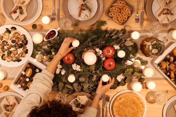 Mãos preparando mesa posta de Natal - Metrópoles