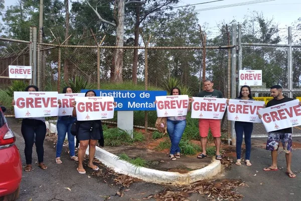 Pessoas seguram placa de greve