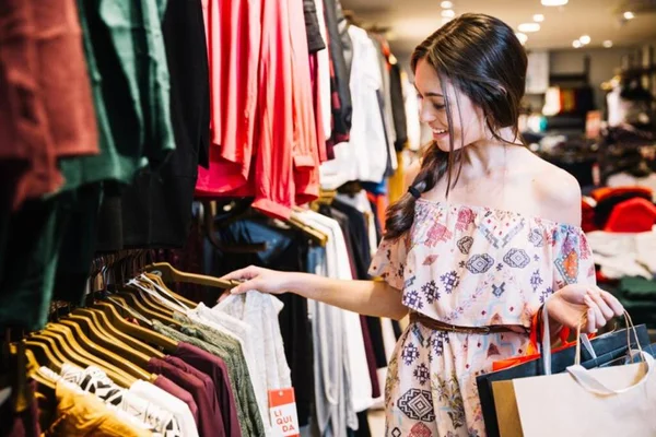moça branca comprando em loja de roupas