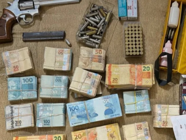 Imagem mostra cédulas, arma e munição apreendidas com quadrilha ligada ao PCC - Metrópoles