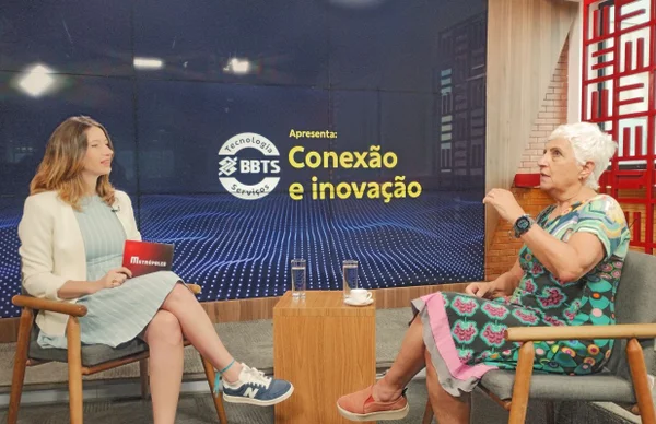 Fotografia colorida mostrando jornalista entrevistando mulher em estúdio-Metrópoles