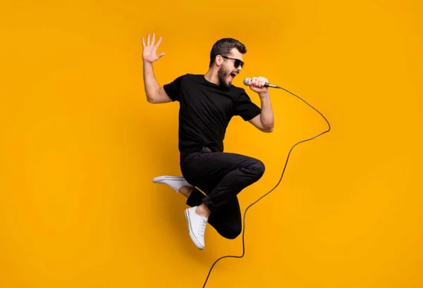 Homem cantando com um microfone na mão
