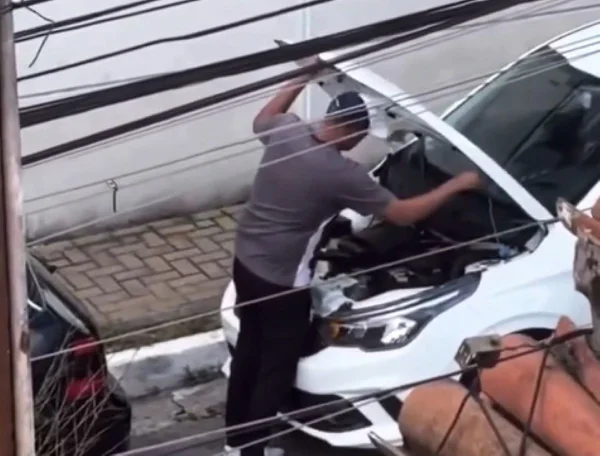 Imagem de homem abrindo capô de carro - Metrópoles