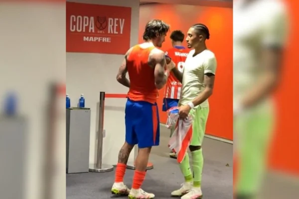Foto colorida de Raphinha e De Paul trocando camisas em Atlético de Madrid x Barcelona - Metrópoles