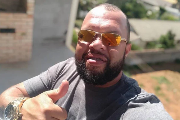 Homem de barba de óculos escuro e camisa cinza