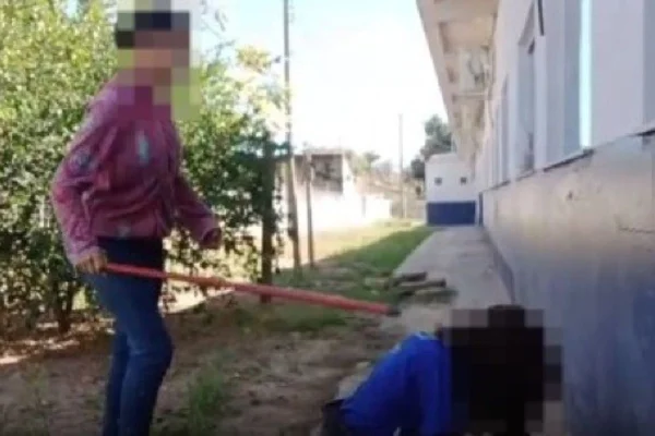Foto colorida e borrada de aluna sofrendo agressão com cabo de vassoura - Metrópoles