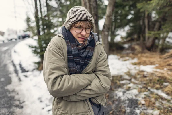 Retrato de um adolescente tremendo no inverno congelante ao ar livre. Metrópoles