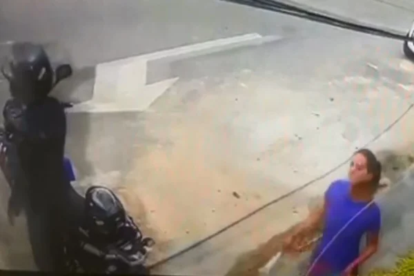 Imagem colorida de uma mulher sendo assaltada por um homem de preto- Metrópoles