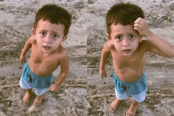 Foto colorida de uma criança com a mão na cabeça - Metrópoles