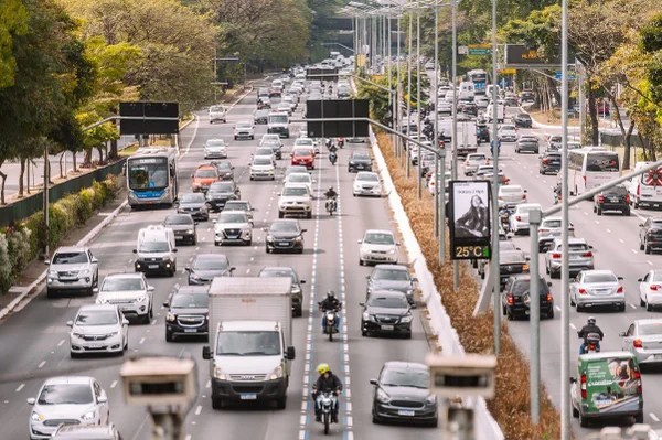 Imagem colorida mostra avenida expressa movimentada com faixa pintada de azul, separada para motociclistas - Metrópoles