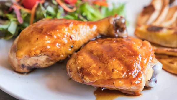 Foto colorida de prato com salada e pedaços de frango
