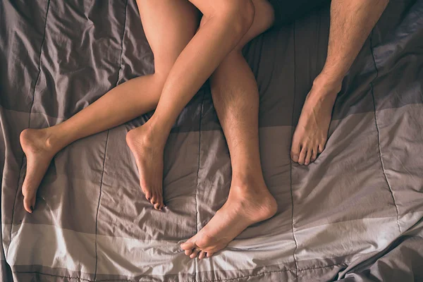 Dois ares de pernas em cima de uma cama