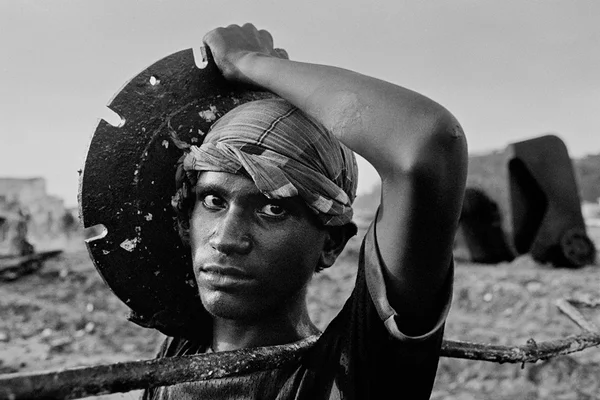 Obra da exposição Trabalhadores, de Sebastião Salgado. A imagem é em preto e branco e registra um homem realizando trabalho braçal - Metrópoles