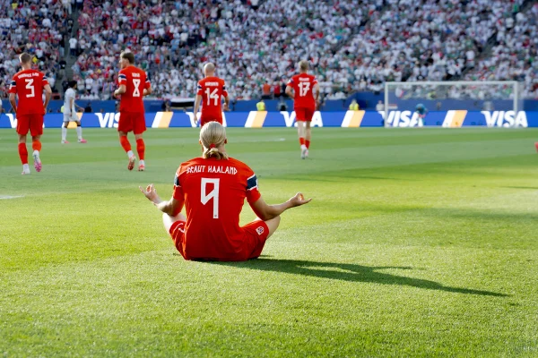 Imagem mostra o atacante Haaland sentado em posição de meditação em meio ao gramado na Copa do Mundo - Metrópoles